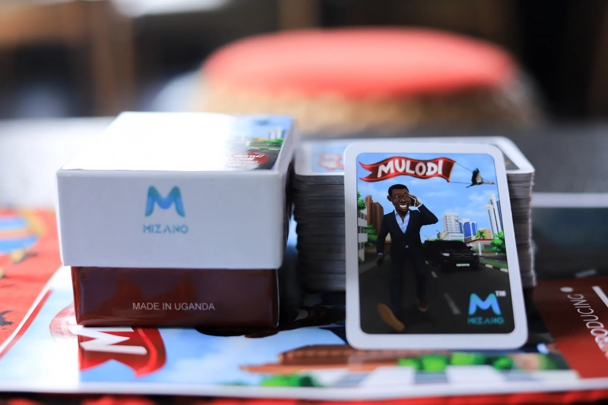 A Mulodi card leaning on its box, stamped Made in Uganda